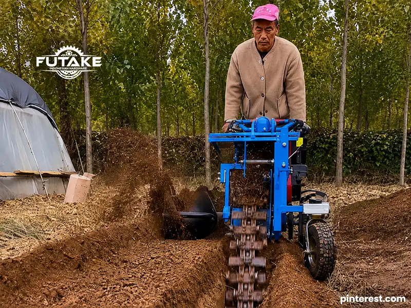penggunaan mesin trencher untuk membuat parit di lahan oleh seorang bapak bapak